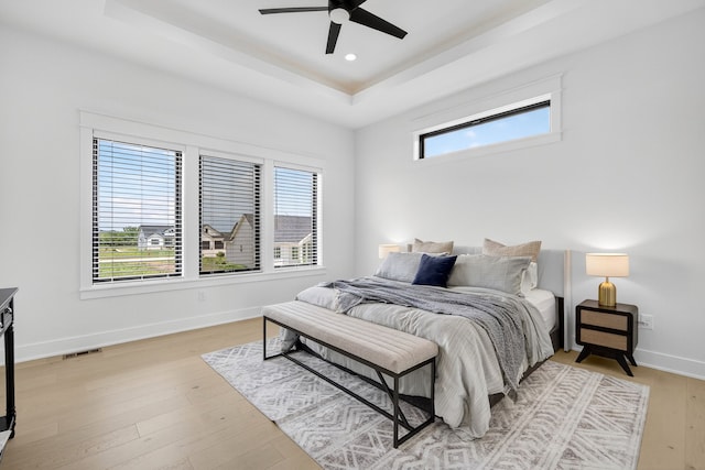1305 NW 28th St, Grimes, IA 50111 - bedroom featuring a raised ceiling, light wood-type flooring, and ceiling fan