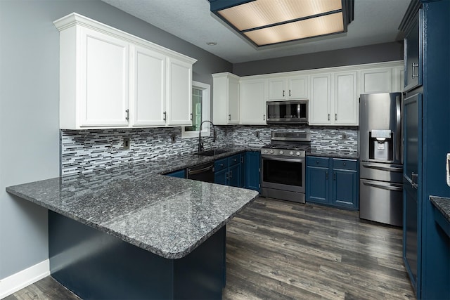 3170 E Kenyon Ave, Des Moines, IA 50320 - kitchen featuring stainless steel appliances, blue cabinets, a peninsula, and decorative backsplash