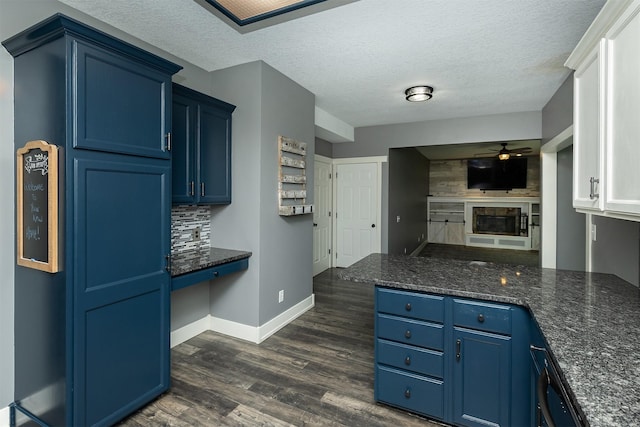 3170 E Kenyon Ave, Des Moines, IA 50320 - kitchen featuring blue cabinetry, ceiling fan, dark wood-type flooring, a peninsula, and a textured ceiling