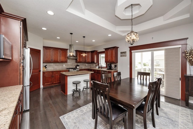 9824 Dunmore Cir, Johnston, IA 50131 - dining space with a chandelier, dark wood finished floors, a raised ceiling, and recessed lighting