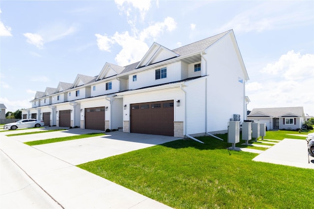 720 Spruce St NW, Bondurant, IA 50035 - view of front of home featuring an attached garage, driveway, a front yard, and stone siding