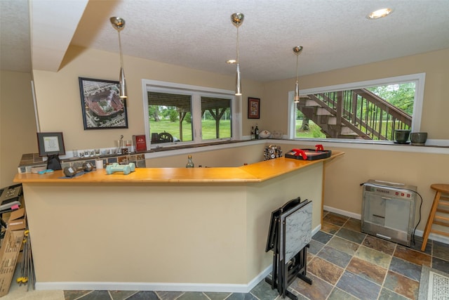 2726 SE 11th St, West Des Moines, IA 50265 - kitchen with dark stone finish floors, a textured ceiling, recessed lighting, hanging light fixtures, and heating unit
