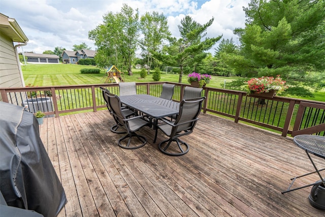 2726 SE 11th St, West Des Moines, IA 50265 - wooden deck with outdoor dining space, a playground, and a lawn