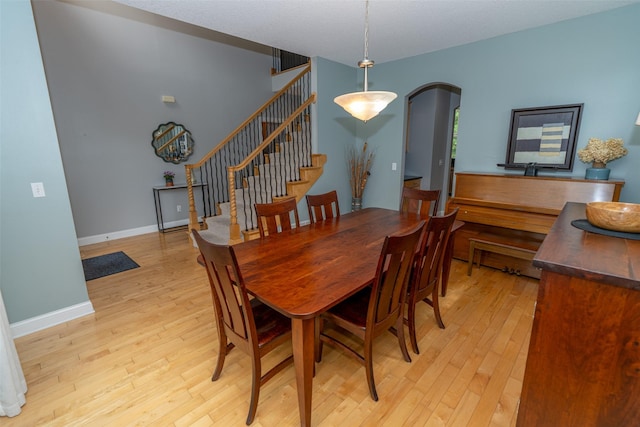 2726 SE 11th St, West Des Moines, IA 50265 - dining room featuring arched walkways, light wood-type flooring, and stairs
