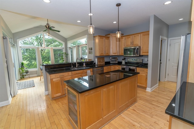 2726 SE 11th St, West Des Moines, IA 50265 - kitchen featuring appliances with stainless steel finishes, a peninsula, light wood-type flooring, ceiling fan, and healthy amount of natural light