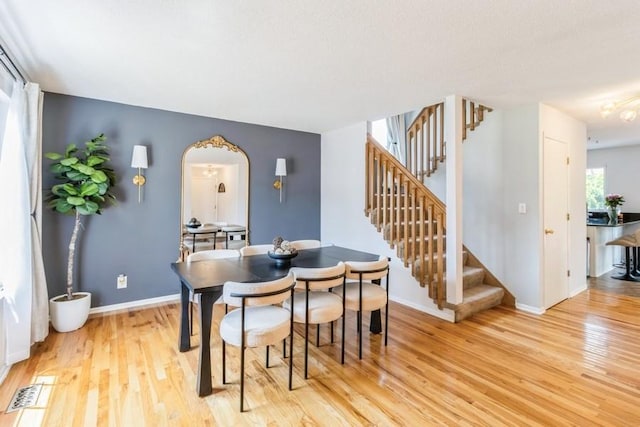 4965 Raintree Dr, West Des Moines, IA 50265 - dining area featuring stairway, light wood-type flooring, and arched walkways