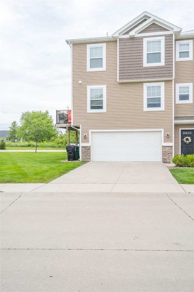 2714 NW Lois Ln, Ankeny, IA 50023 - view of front facade featuring driveway, a garage, stone siding, and a front lawn
