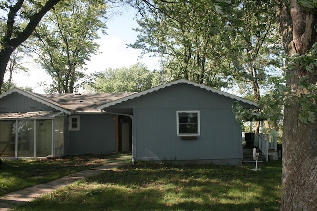 13018 137th Ave, Plano, IA 52581 - back of house featuring a lawn and a sunroom
