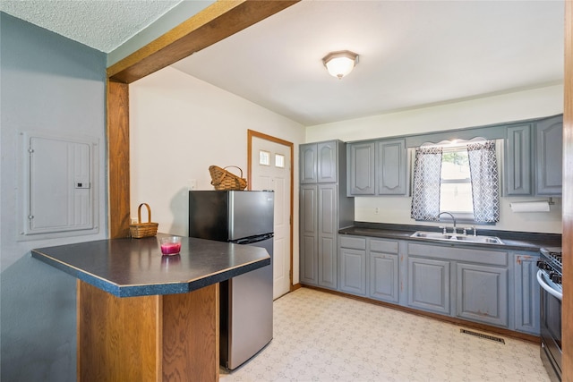 4935 NE 39th Ave, Des Moines, IA 50317 - kitchen featuring dark countertops, gray cabinets, stainless steel appliances, a peninsula, and electric panel