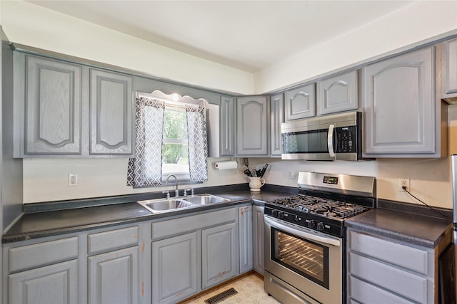 4935 NE 39th Ave, Des Moines, IA 50317 - kitchen featuring stainless steel appliances, gray cabinets, and dark countertops