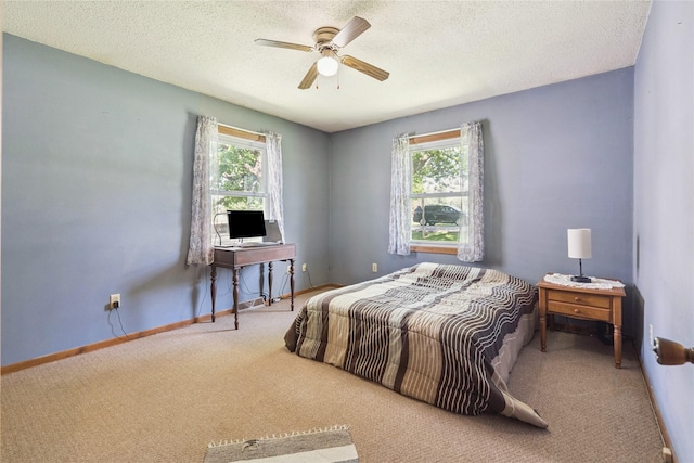 4935 NE 39th Ave, Des Moines, IA 50317 - carpeted bedroom featuring multiple windows, a textured ceiling, and ceiling fan