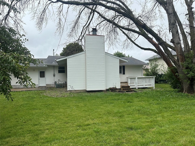 1205 S 4th St, Marshalltown, IA 50158 - back of property featuring a wooden deck, a chimney, roof with shingles, and a yard