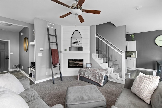 2817 NW Lois Ln, Ankeny, IA 50023 - carpeted living area featuring a ceiling fan, a large fireplace, and stairway