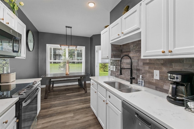 2817 NW Lois Ln, Ankeny, IA 50023 - kitchen featuring stainless steel microwave, electric range oven, light countertops, white cabinets, and tasteful backsplash