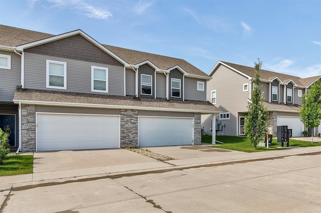 2817 NW Lois Ln, Ankeny, IA 50023 - view of property featuring stone siding, concrete driveway, an attached garage, board and batten siding, and a residential view