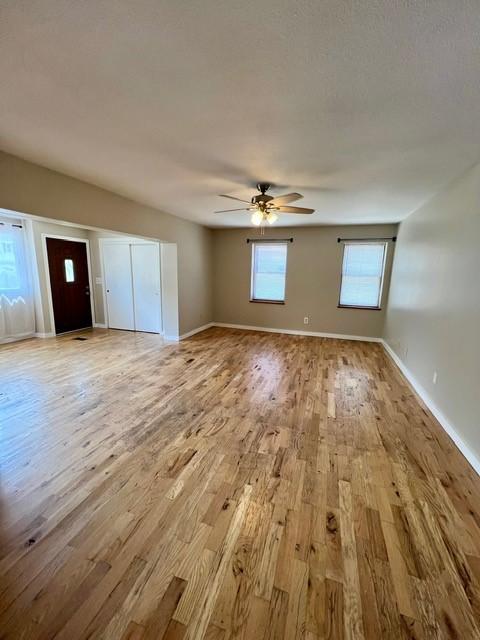 1506 Main St, Adel, IA 50003 - unfurnished living room with light wood-type flooring and a ceiling fan