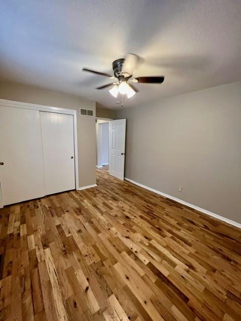 1506 Main St, Adel, IA 50003 - unfurnished bedroom with wood finished floors, a closet, and a ceiling fan