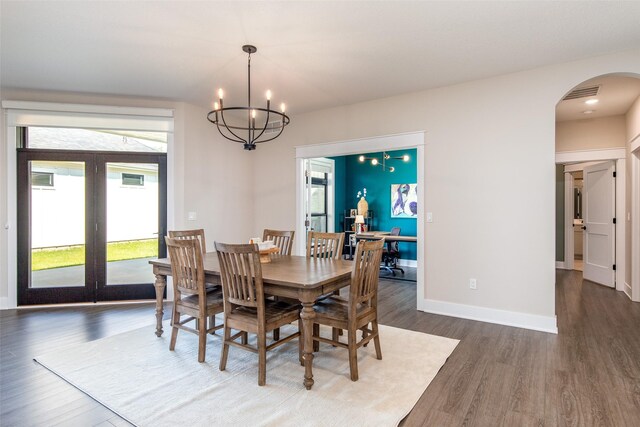 2930 Green Hills Dr, Ames, IA 50014 - dining space featuring arched walkways, wood finished floors, a chandelier, and french doors