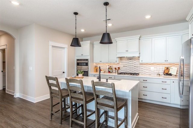 2930 Green Hills Dr, Ames, IA 50014 - kitchen featuring stainless steel appliances, arched walkways, tasteful backsplash, light countertops, and recessed lighting