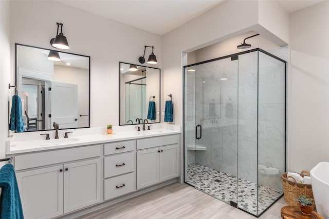 2930 Green Hills Dr, Ames, IA 50014 - full bath with a shower stall, double vanity, a freestanding bath, and wood finished floors