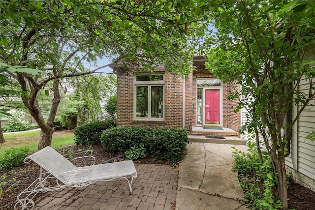 1069 Glen Oaks Dr, West Des Moines, IA 50266 - view of exterior entry featuring brick siding and a patio area