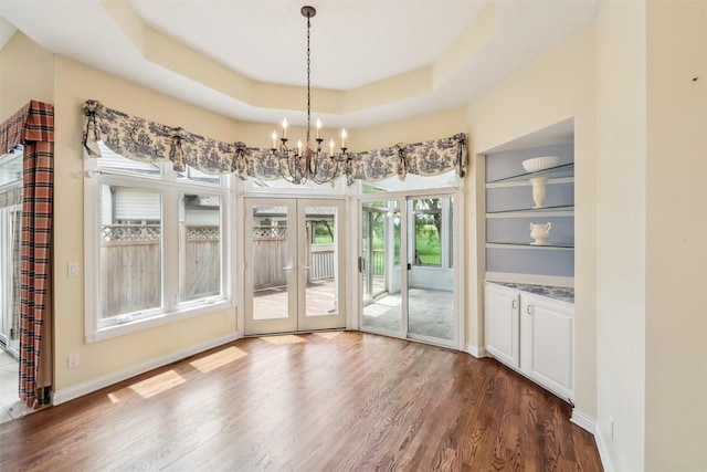 1069 Glen Oaks Dr, West Des Moines, IA 50266 - unfurnished dining area featuring a chandelier, dark wood-style floors, french doors, and a raised ceiling
