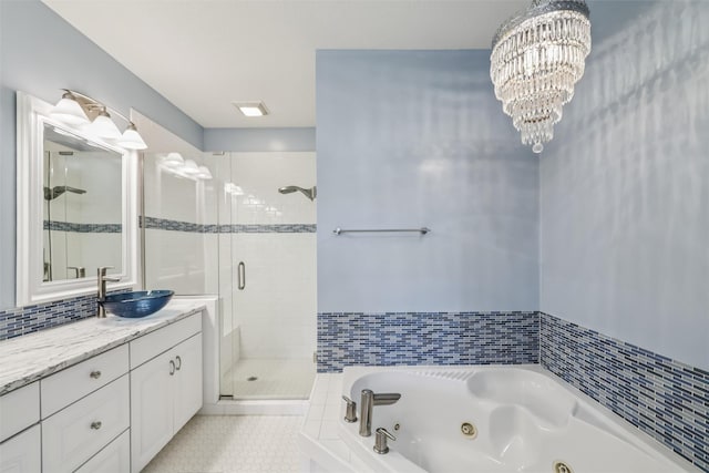 1069 Glen Oaks Dr, West Des Moines, IA 50266 - bathroom with a stall shower, a tub with jets, vanity, tile patterned floors, and a chandelier