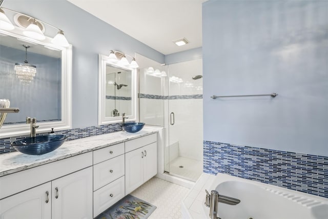 1069 Glen Oaks Dr, West Des Moines, IA 50266 - bathroom with a shower stall, double vanity, a tub with jets, tile patterned floors, and decorative backsplash