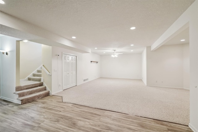 1069 Glen Oaks Dr, West Des Moines, IA 50266 - finished below grade area with recessed lighting, stairway, ceiling fan, wood finished floors, and a textured ceiling