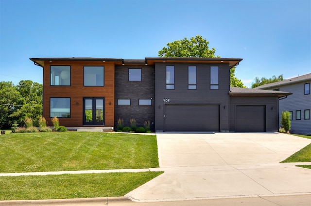 989 65th St, West Des Moines, IA 50266 - view of front of house with driveway, a front lawn, an attached garage, and a garage
