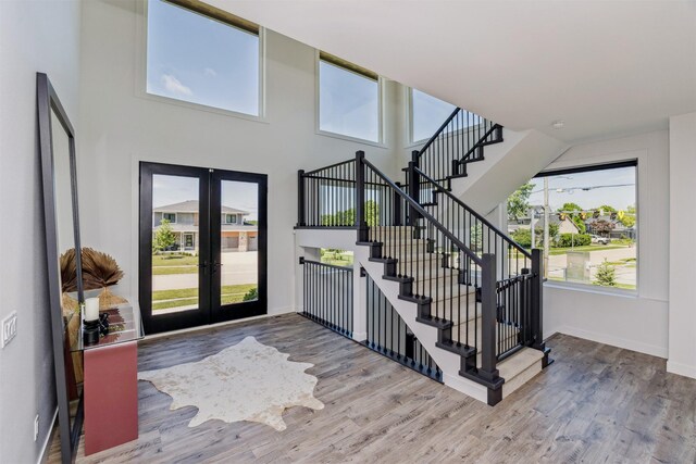 989 65th St, West Des Moines, IA 50266 - foyer featuring french doors, stairs, healthy amount of natural light, wood finished floors, and a towering ceiling