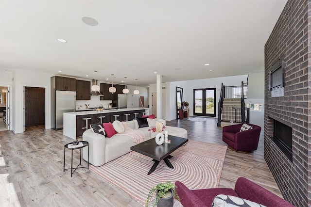 989 65th St, West Des Moines, IA 50266 - living room featuring a brick fireplace, light wood-style floors, and recessed lighting