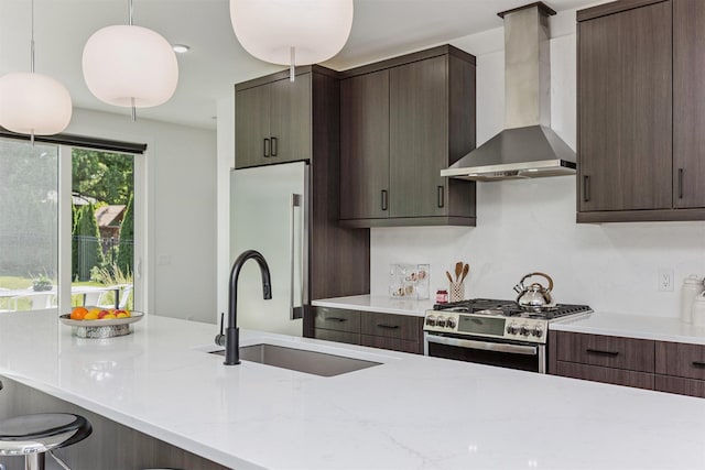 989 65th St, West Des Moines, IA 50266 - kitchen with wall chimney range hood, stainless steel gas range oven, freestanding refrigerator, dark brown cabinets, and pendant lighting