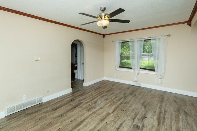 2421 Adams Ave, Des Moines, IA 50310 - unfurnished room featuring arched walkways, wood finished floors, ornamental molding, and a ceiling fan