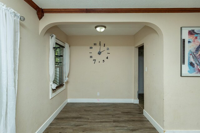 2421 Adams Ave, Des Moines, IA 50310 - unfurnished dining area with arched walkways, dark wood-style floors, and ornamental molding