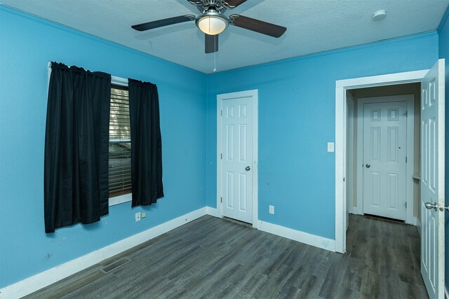 2421 Adams Ave, Des Moines, IA 50310 - unfurnished bedroom with dark wood-style flooring, ceiling fan, and a textured ceiling
