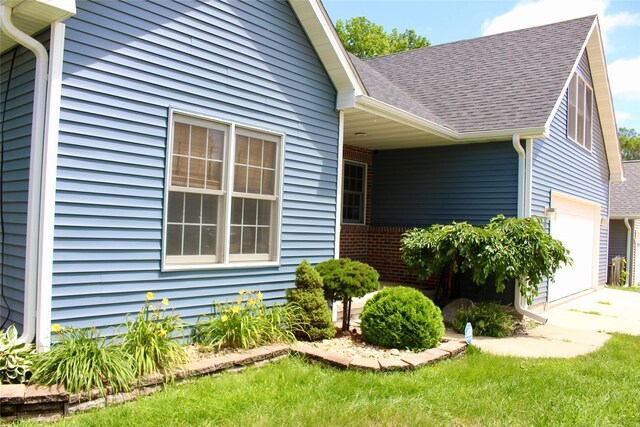4015 Marigold Dr, Ames, IA 50014 - view of property exterior with a garage, a shingled roof, driveway, and a lawn