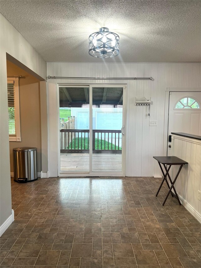 2612 Grandview Ave, Des Moines, IA 50317 - unfurnished room featuring a textured ceiling, a chandelier, and wooden walls