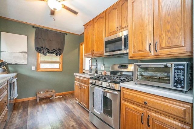 305 E 20th St S, Newton, IA 50208 - kitchen featuring appliances with stainless steel finishes, crown molding, a ceiling fan, dark wood-style flooring, and light countertops