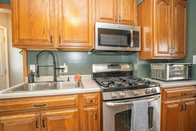 305 E 20th St S, Newton, IA 50208 - kitchen featuring stainless steel appliances, light countertops, and brown cabinetry