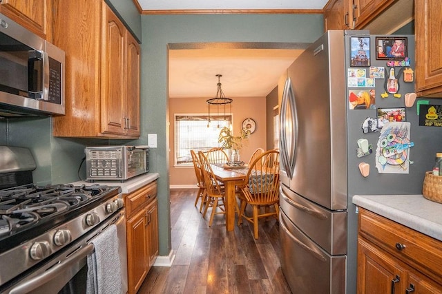 305 E 20th St S, Newton, IA 50208 - kitchen with stainless steel appliances, dark wood finished floors, brown cabinets, light countertops, and ornamental molding