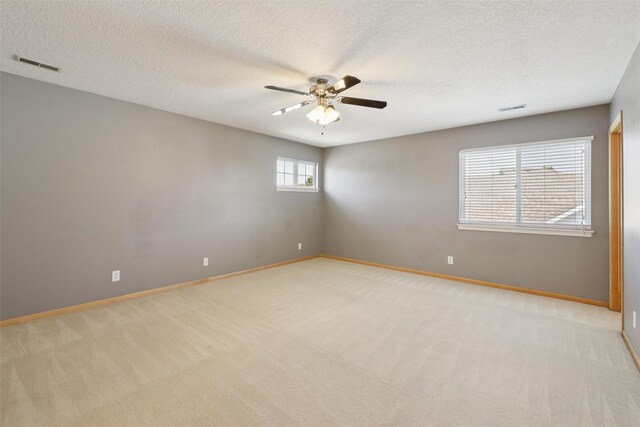 7039 Carey Ct, Johnston, IA 50131 - spare room with light carpet, ceiling fan, and a textured ceiling