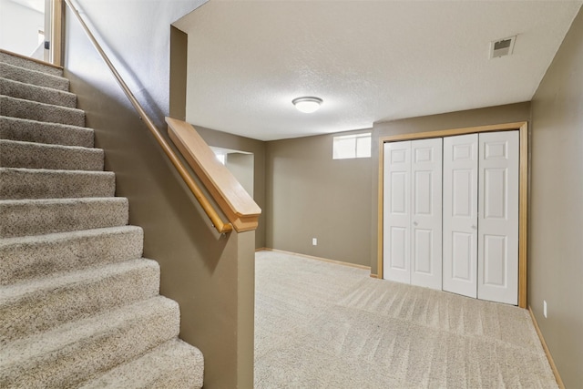 7039 Carey Ct, Johnston, IA 50131 - staircase with carpet flooring and a textured ceiling