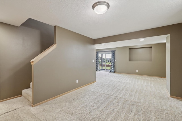 7039 Carey Ct, Johnston, IA 50131 - below grade area with carpet floors, stairway, and a textured ceiling