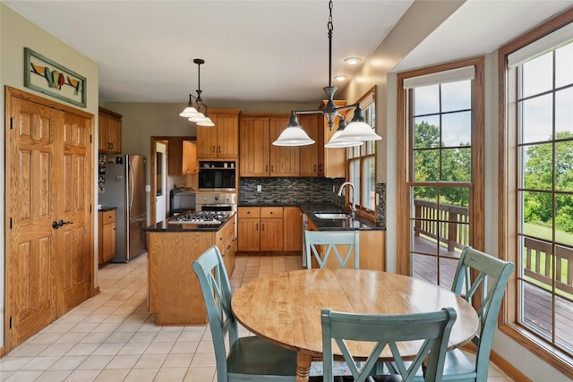 940 High Ave, Newton, IA 50208 - kitchen featuring appliances with stainless steel finishes, light tile patterned floors, a center island, and backsplash