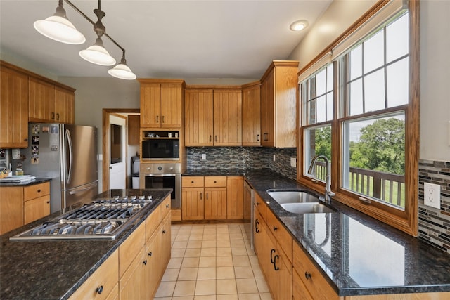 940 High Ave, Newton, IA 50208 - kitchen with appliances with stainless steel finishes, decorative backsplash, pendant lighting, dark stone countertops, and light tile patterned flooring