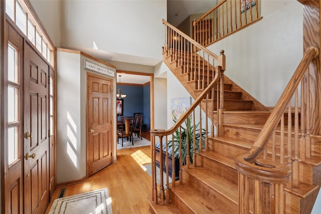 940 High Ave, Newton, IA 50208 - entrance foyer featuring a high ceiling, light wood-type flooring, stairs, and a chandelier