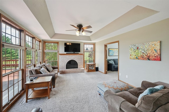 940 High Ave, Newton, IA 50208 - living area featuring a tray ceiling, ceiling fan, carpet flooring, and a brick fireplace