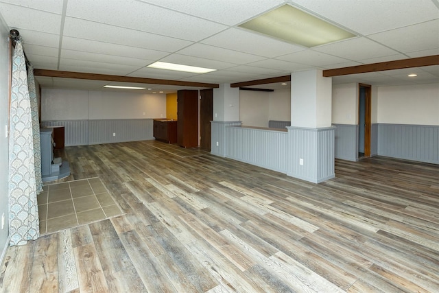 1560 Castlegar Ct, Pleasant Hill, IA 50327 - unfurnished living room with wainscoting, a paneled ceiling, a wood stove, and wood finished floors