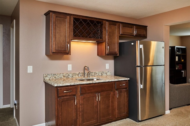 358 S 85th St, West Des Moines, IA 50266 - kitchen featuring freestanding refrigerator, light carpet, light stone countertops, and dark brown cabinetry